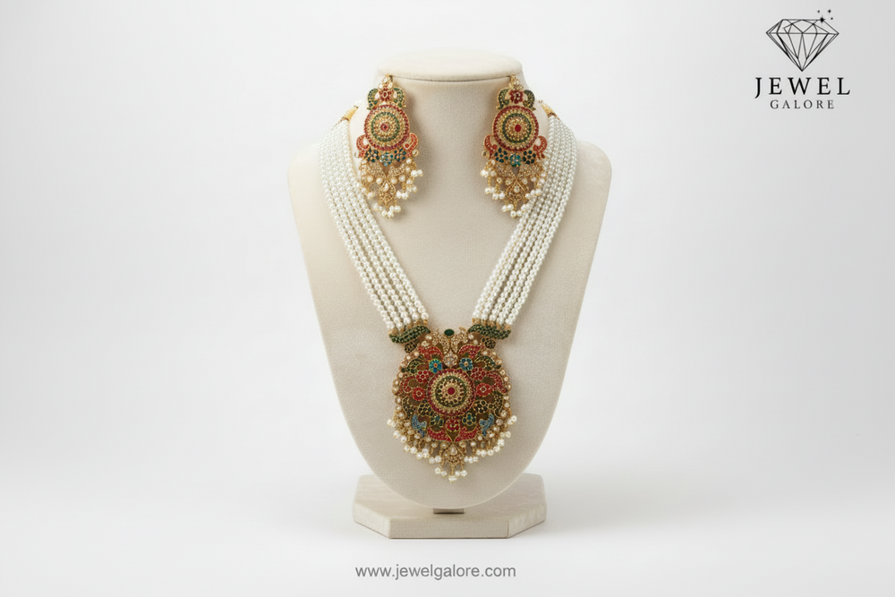 Traditional pearl necklace set with multicolored floral design pendant and matching earrings, displayed on a black background.