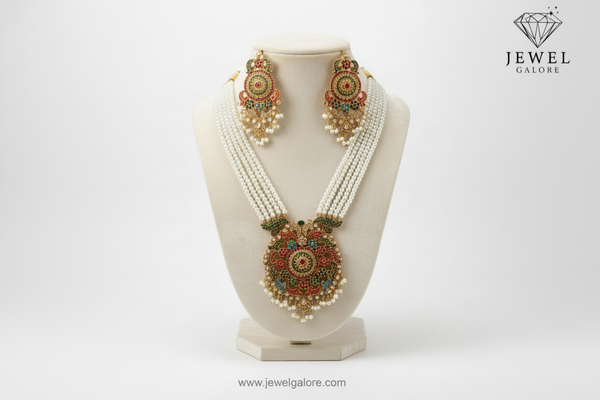 Traditional pearl necklace set with multicolored floral design pendant and matching earrings, displayed on a black background.
